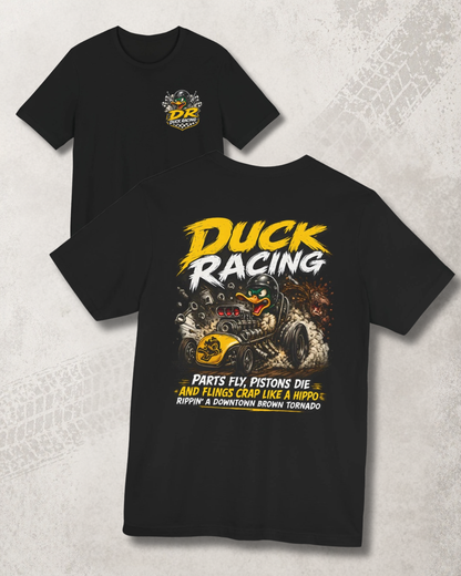 Black t-shirt with duck racing graphic and 'Parts Fly, Pistons Die, And Flings Crap Like A Hippo Rippin A Downtown Brown Tornado' text on a textured gray background