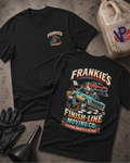 Two black graphic T-shirts laid flat on a textured gray surface, with automotive-themed artwork and the text 'Frankie's Finish-Line Moving Co.' The front shirt shows a small chest logo, and the back shirt shows a large multicolor graphic with cars and moving-cooperation imagery.