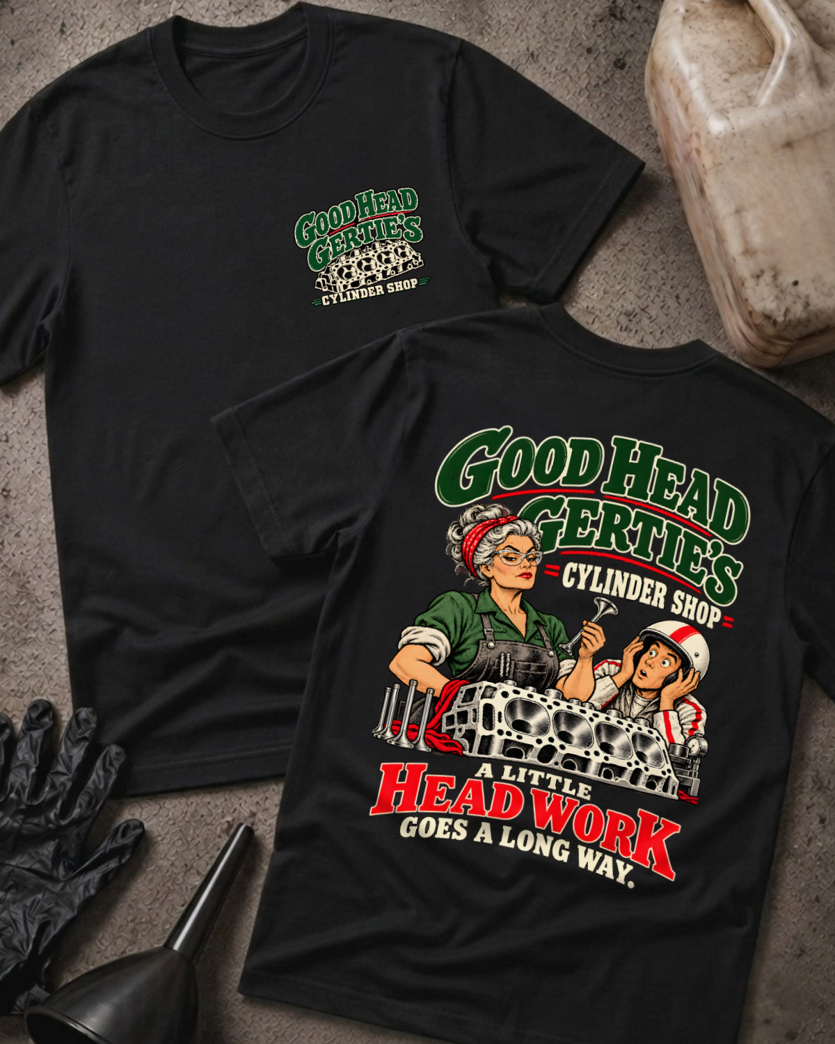 Black Good Head Gertie’s Cylinder Shop T-shirt showing the front chest logo and back cartoon of a woman machinist machining a cylinder head beside a racer in a helmet, “A Little Head Work Goes a Long Way,” with gloves, funnel, and oil jug.