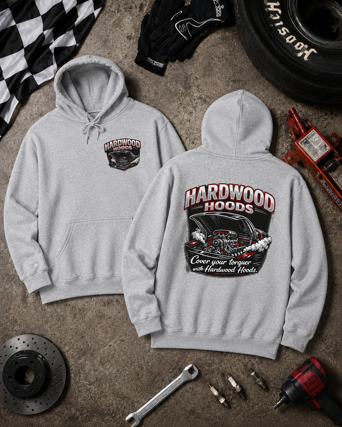 Gray hoodie with 'Hardwood Hoods' branding on a textured surface with automotive tools and parts.