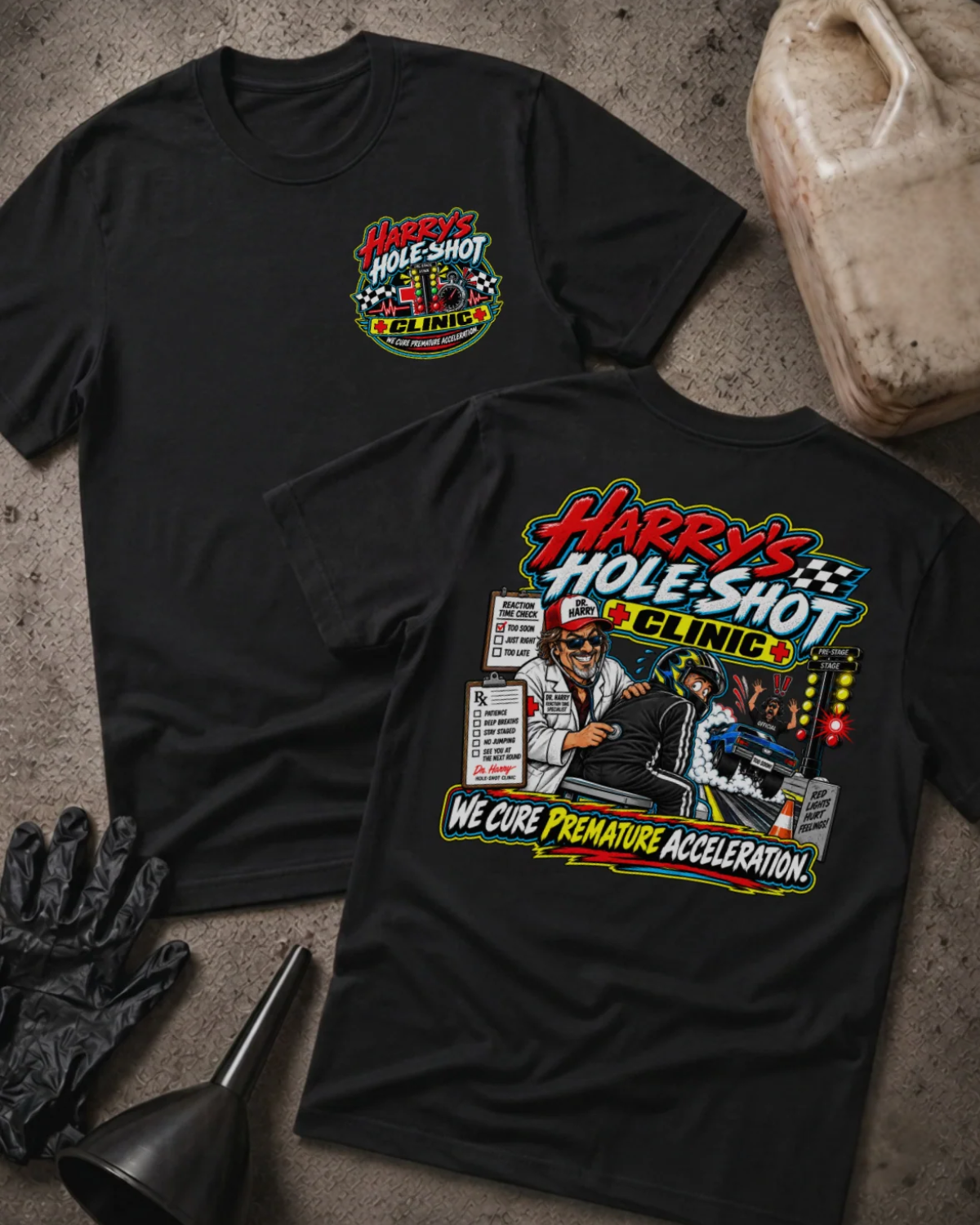 Front and back of Harry’s Hole-Shot Clinic black T-shirt with chest logo, doctor examining a helmeted racer, drag racing lights, and “We cure premature acceleration” slogan.