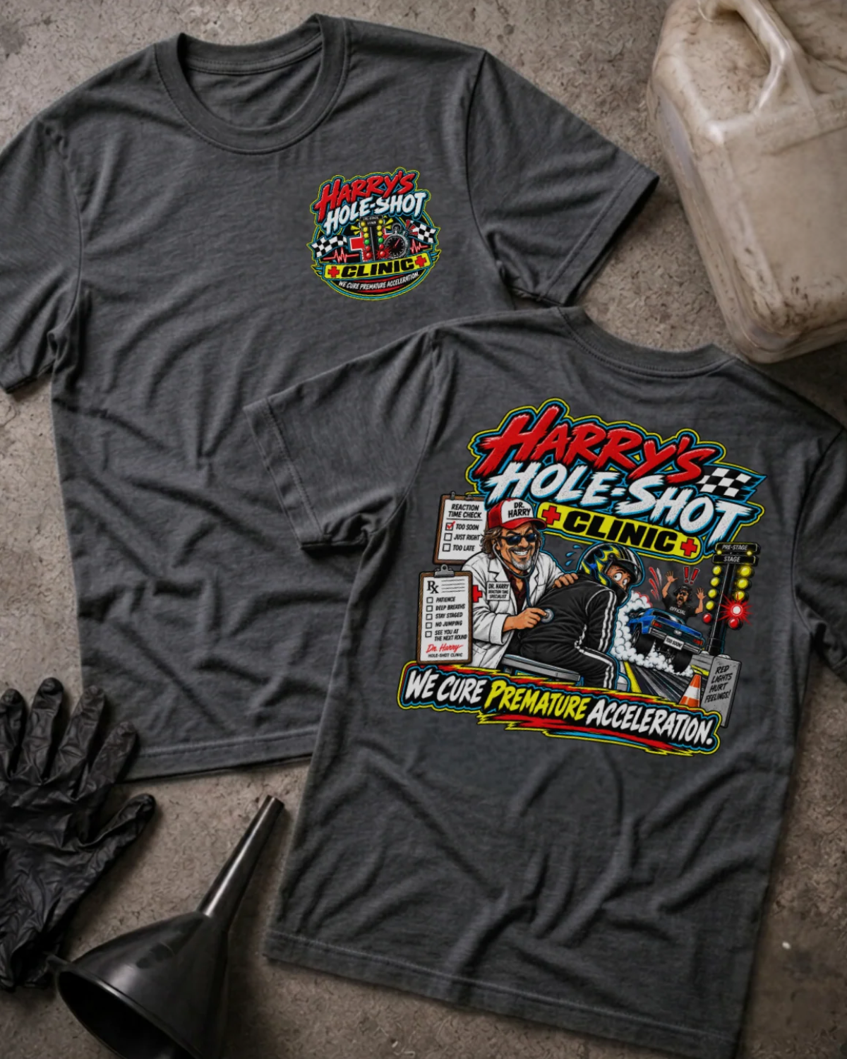 Front and back of Harry’s Hole-Shot Clinic dark grey heather T-shirt with chest logo, doctor examining a helmeted racer, drag racing lights, and “We cure premature acceleration” slogan.