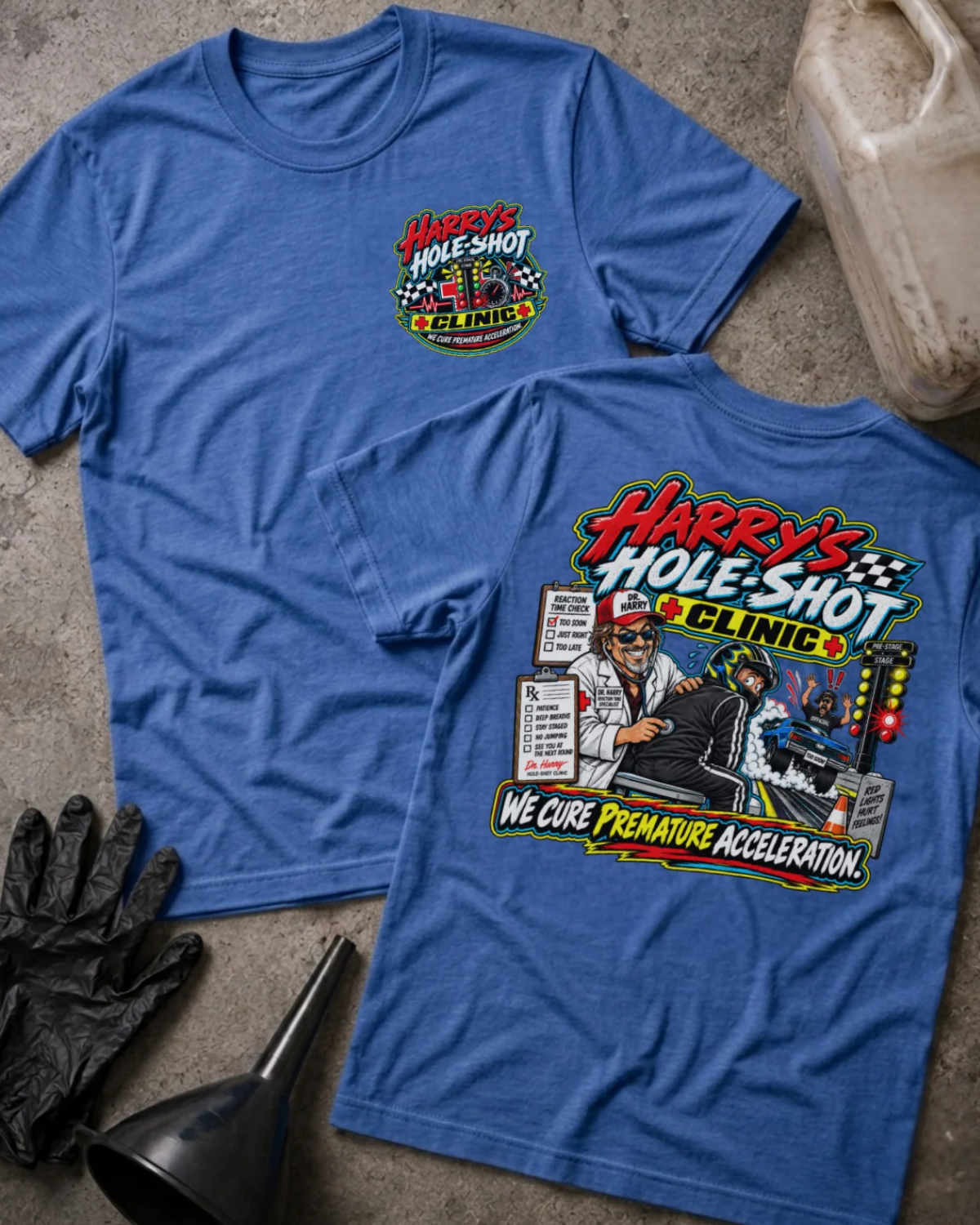 Front and back of Harry’s Hole-Shot Clinic heather true royal T-shirt with chest logo, doctor examining a helmeted racer, drag racing lights, and “We cure premature acceleration” slogan.
