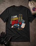 A black graphic t-shirt laid flat on a textured gray surface, surrounded by racing-themed props including a gas bottle, gloves, and a funnel. The graphic features the text 'I CAME. I STAGED. I RED-LIT.'