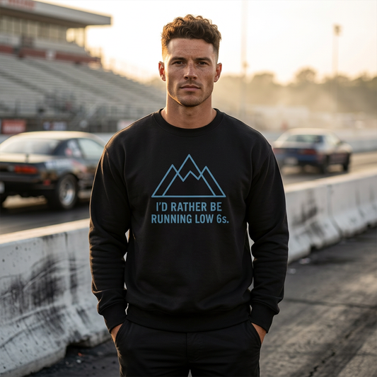 Man wearing a black sweatshirt with a graphic and 'I'd Rather Be Running Low 6s' text, standing on a race track.
