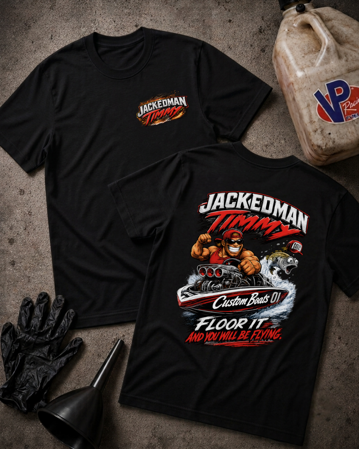 Two black graphic T-shirts laid flat on a textured gray surface, with racing-themed artwork and the text 'Jackedoman Timmy' on the chest and back. Black gloves and a funnel are placed beside them, and a plastic jug is partially visible at the top right.