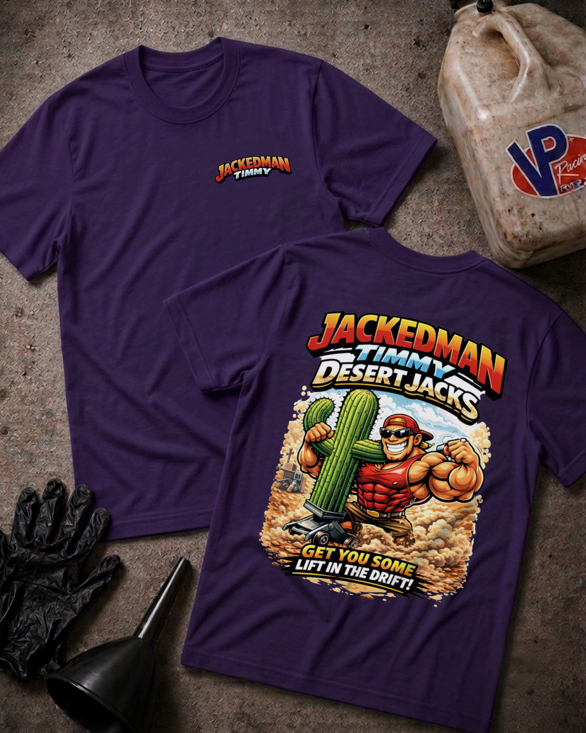Two purple graphic t-shirts displayed on a textured concrete floor with workshop props like a black funnel, black gloves, and a plastic jug. The front shirt shows a small 'JACKEDMAN TIMMY' logo on the left chest, and the back shirt features a large graphic of a muscular man lifting a cactus with the text 'JACKEDMAN TIMMY DESERT JACKS' and 'GET YOU SOME LIFT IN THE DRIFT!'.