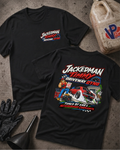 Two black graphic T-shirts laid flat on a textured gray surface, with racing-themed printed artwork and the text 'JACKEDMAN TIMMY DRIVEWAY DYNO.' One shirt shows the front with a small chest print, and the other shows the back with a large multicolor graphic.