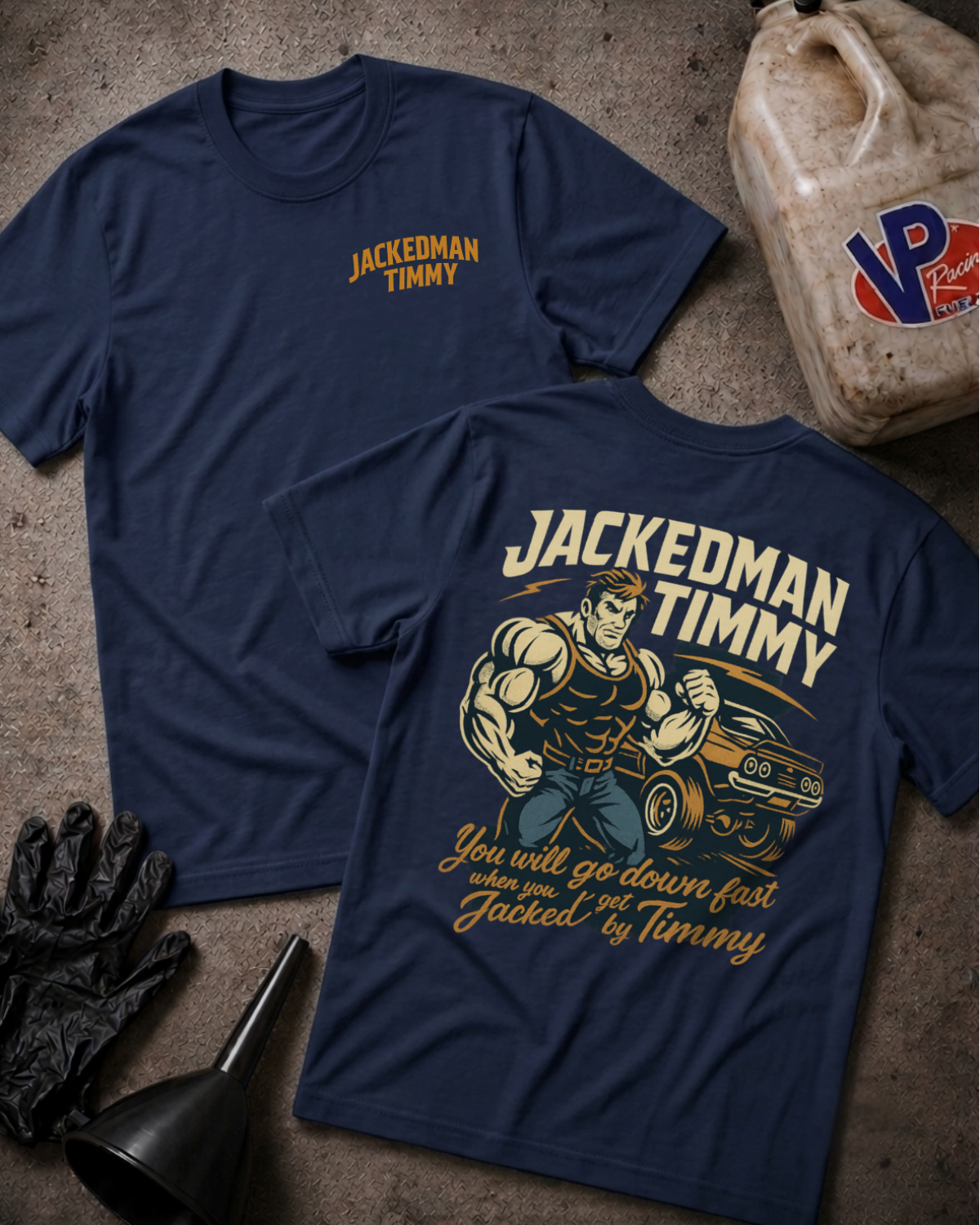 Two navy blue graphic T-shirts laid flat on a textured concrete-like surface, with a jugs bucket, gloves, and funnel as styled props. The front shirt shows a small yellow 'JACKEDMAN TIMMY' chest print, and the back shirt shows a large vintage-style muscular man driving a car with cream and yellow text reading 'JACKEDMAN TIMMY' and 'You will go down fast when you get Jacked by Timmy.