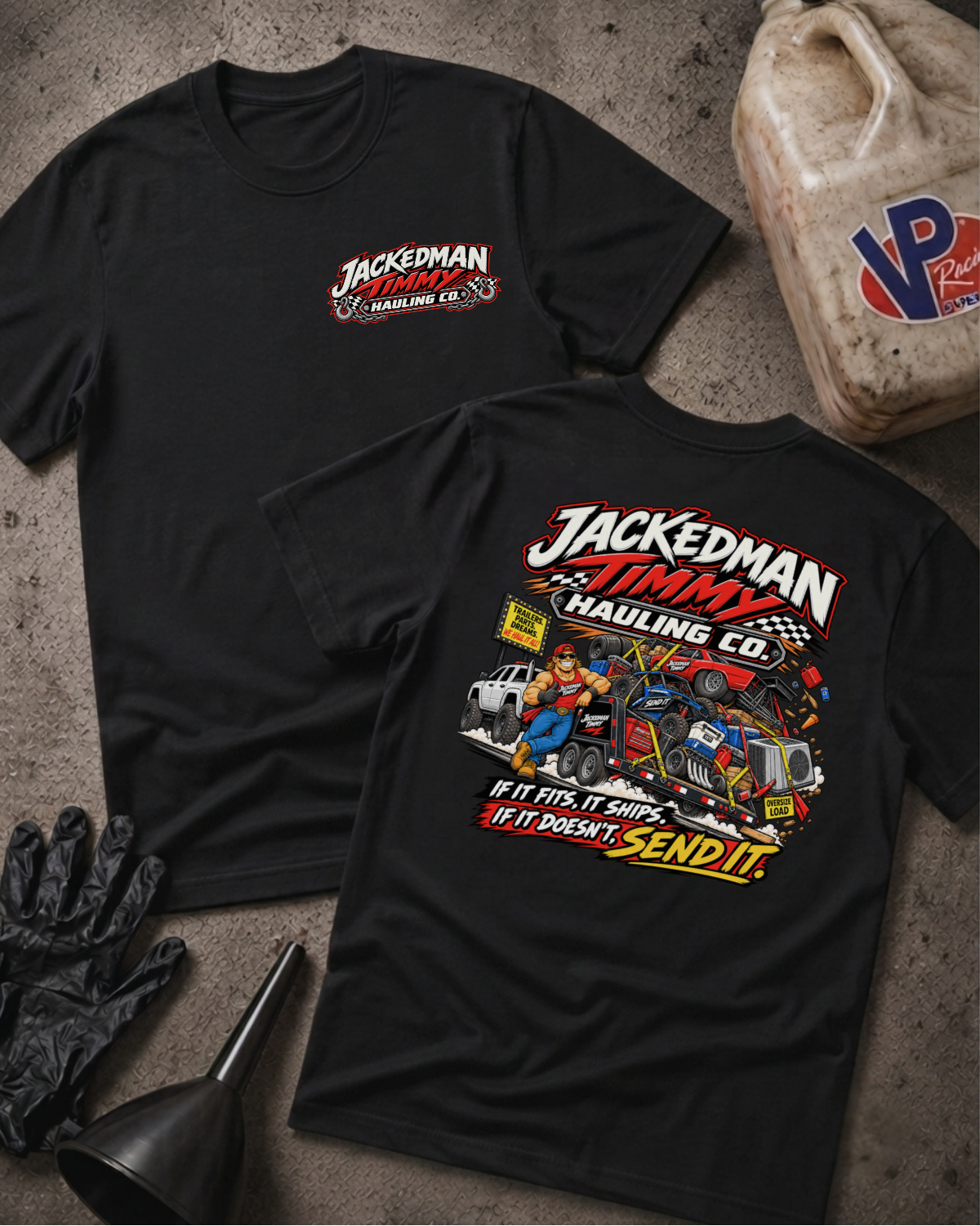 Two black graphic T-shirts laid flat on a textured gray surface, surrounded by racing-themed props including a jerrycan, gloves, funnel, and checkered flag. The front shirt shows a large multicolor chest graphic with the text 'JACKEDMAN JIMMY HAULING CO.