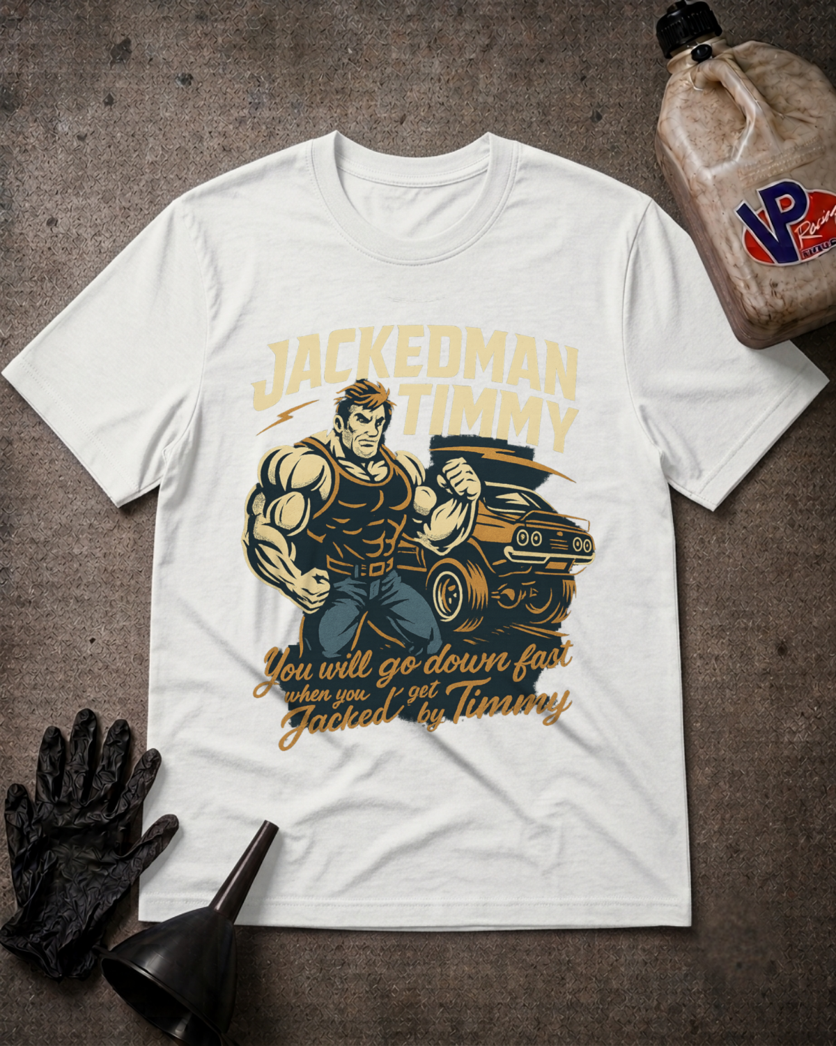 A white graphic t-shirt featuring a muscular man holding a car next to the text 'JACKEDMAN TIMMY' and 'You will go down fast when you get Jacked by Timmy', styled in a flat-lay with black gloves, a funnel, and a bottle on a textured gray background.