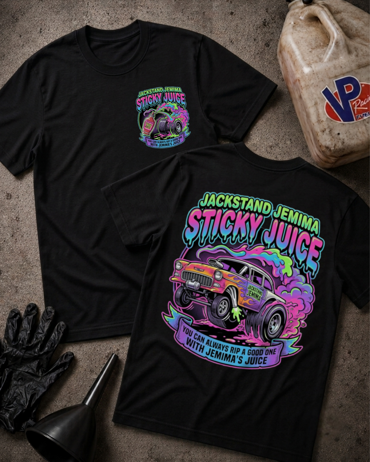Two black graphic T-shirts laid flat on a textured concrete-like surface, showing the front and back designs. The shirts feature a colorful hot-rod truck and the text 'Jackstand Jemima Sticky Juice' with additional stylized lettering.
