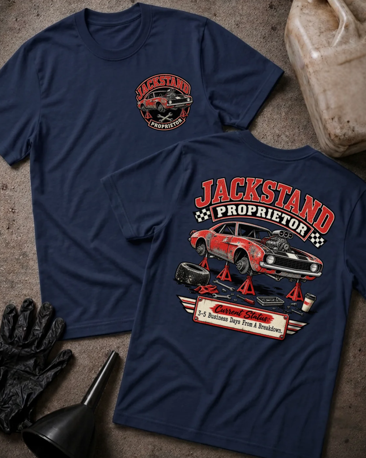 Front and back of Jackstand Proprietor navy T-shirt with chest logo, weathered red muscle car on jack stands, and “Current status: 3–5 business days from a breakdown” slogan.