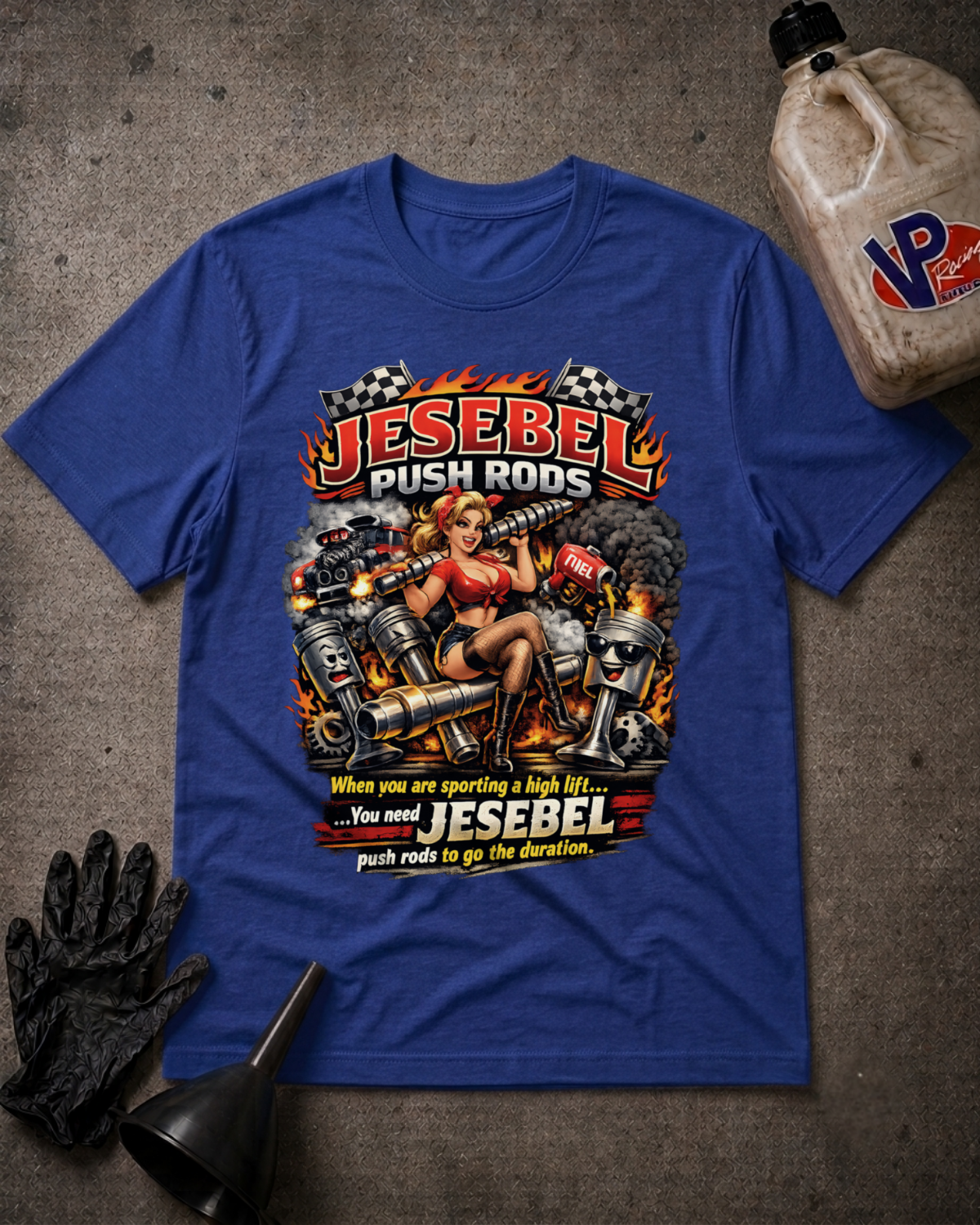 A royal blue graphic t-shirt featuring a pin-up style illustration of a woman with pistons and flames, with the text 'JESEBEL PUSH RODS' and 'When you are sporting a high lift. You need JESEBEL push rods to go the duration.'