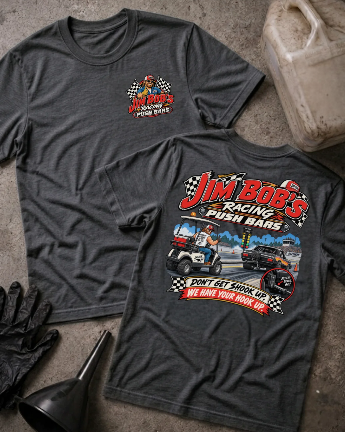 Front and back of Jim Bob’s Racing Push Bars dark grey heather T-shirt with chest logo, man driving a golf cart behind a drag car, and “Don’t get shook up. We have your hook up.” slogan.