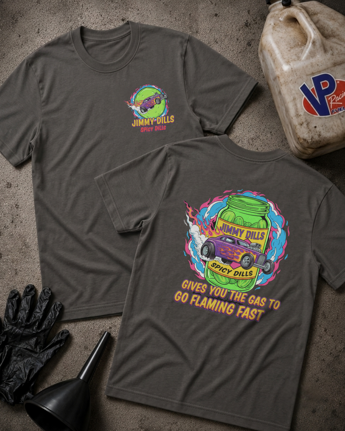 Two dark gray graphic t-shirts displayed flat on a textured concrete surface, showing both the front and back designs. The shirts feature a colorful 'Jimmy Dills Spicy Dills' graphic.