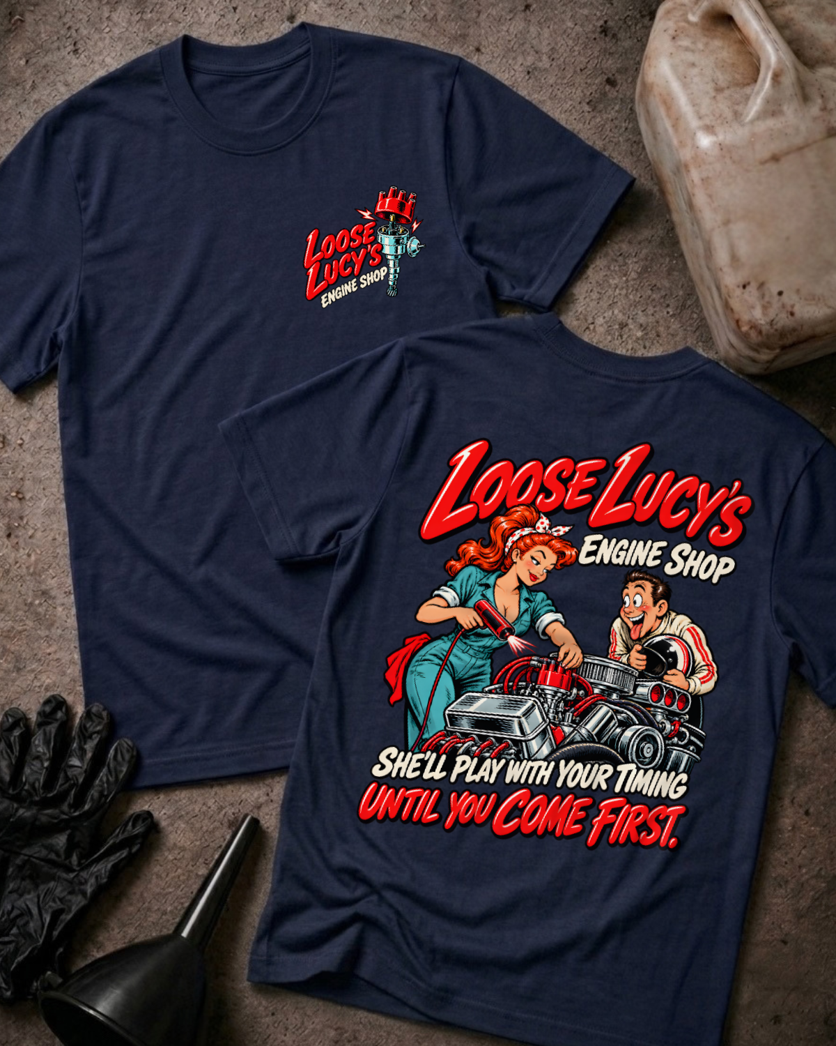 Navy Loose Lucy’s Engine Shop T-shirt showing the front chest logo and back cartoon of a woman mechanic timing a hot rod engine with a timing light, “She’ll Play With Your Timing Until You Come First,” with gloves, funnel, and oil jug props.