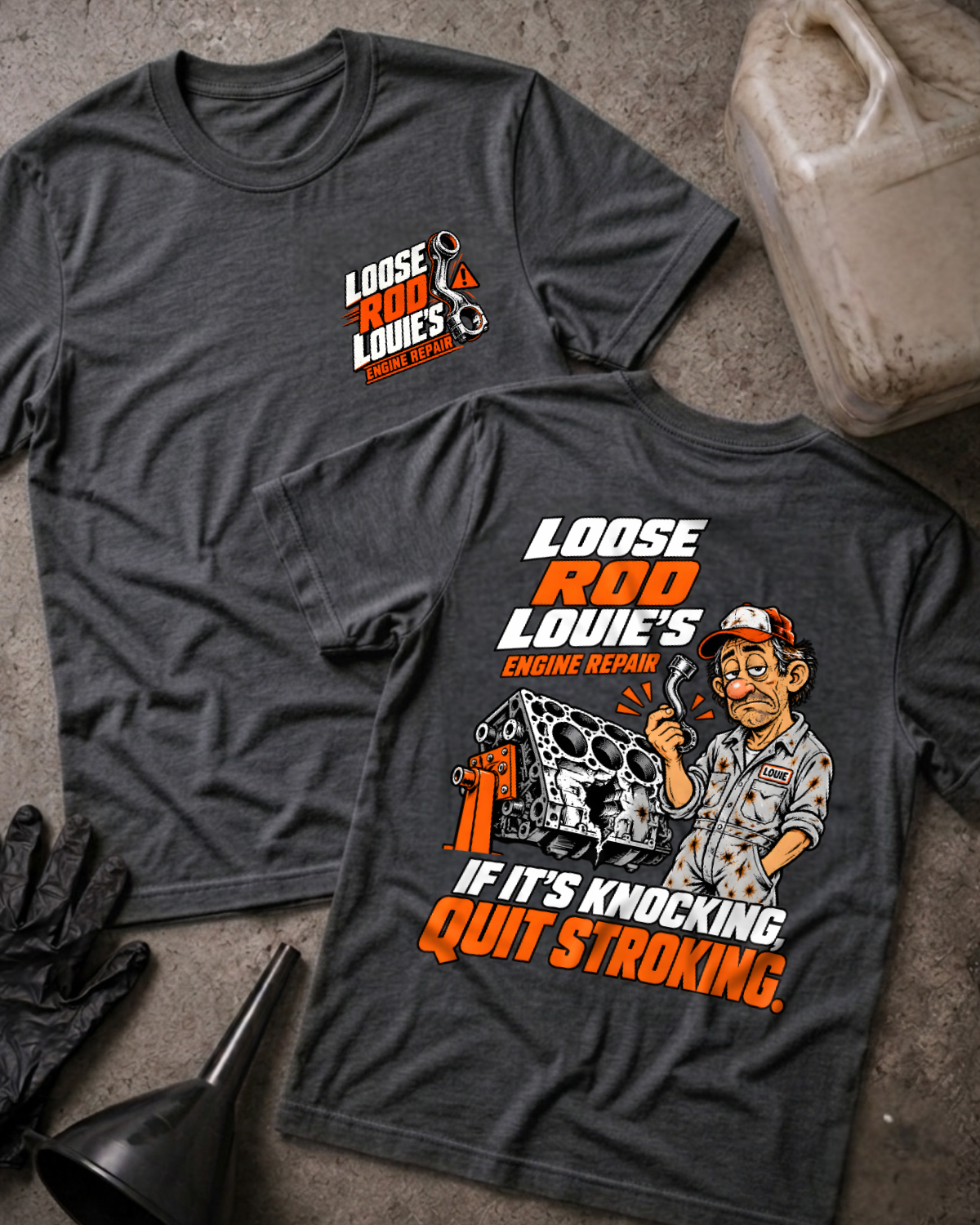 Dark grey heather Loose Rod Louie’s Engine Repair T-shirt, flat lay with the front chest logo and back cartoon mechanic and cracked engine block design reading “If It’s Knocking, Quit Stroking,” styled with gloves, a funnel, and an oil jug.