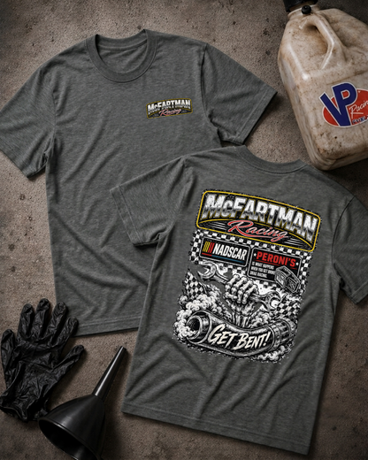 Two heather gray t-shirts displayed flat on a textured concrete surface, with a black funnel and gloves at the bottom left and a plastic jug at the top right. The front shirt shows a small 'McCartman Racing' chest logo, while the back shirt features a large graphic with 'McCartman Racing', 'NADSCAR', 'Peroni's', and 'Get Bent!'.