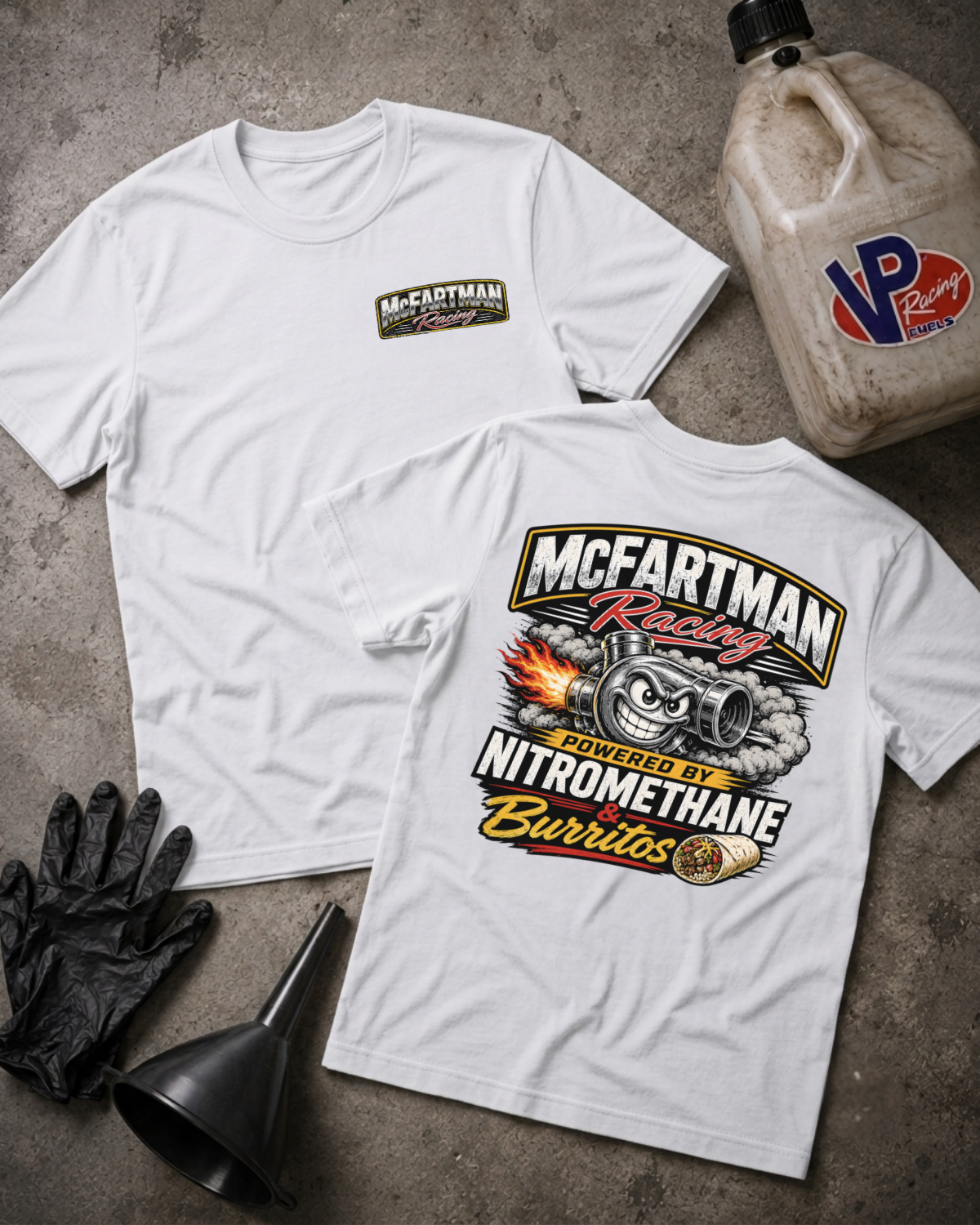 Two white graphic T-shirts laid flat on a gray concrete surface, with a black funnel, black gloves, and a dirty plastic jug. The front shirt has a small McFartman Racing logo on the left chest, and the back shirt has a large racing graphic with the text 'McFartman Racing' and 'Powered by Nitromethane Burritos.