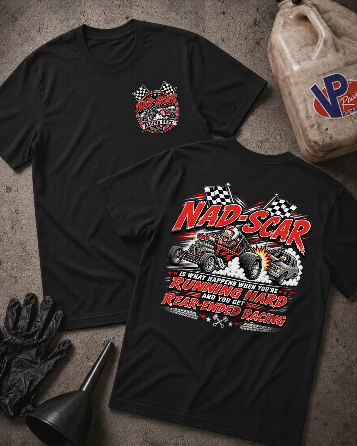 Two black graphic T-shirts laid flat on a textured gray surface, with automotive-themed printed artwork and the text 'NAD-SCAR IS WHAT HAPPENS WHEN YOU'RE RUNNING HARD AND YOU GET REAR-ENDED RACING.' One shirt shows a small circular chest logo, and the other shows a large back graphic with an drag racing illustration and the phrase 'NAD-SCAR IS WHAT HAPPENS WHEN YOU'RE RUNNING HARD AND YOU GET REAR-ENDED RACING'.