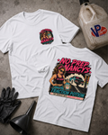 Two white graphic T-shirts laid flat on a concrete surface, showing the front and back designs. The front has a small circular chest graphic, and the back has a large colorful graphic with the text 'NO PREP NANCY'S' and 'TRACTION POTION.