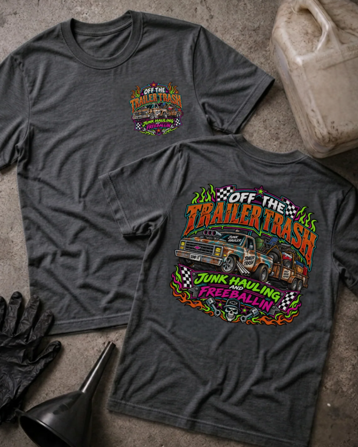 Front and back of Off the Trailer Trash dark grey heather T-shirt with chest logo, rusty pickup towing a junk-filled trailer, and “Junk hauling and freeballin’” slogan.