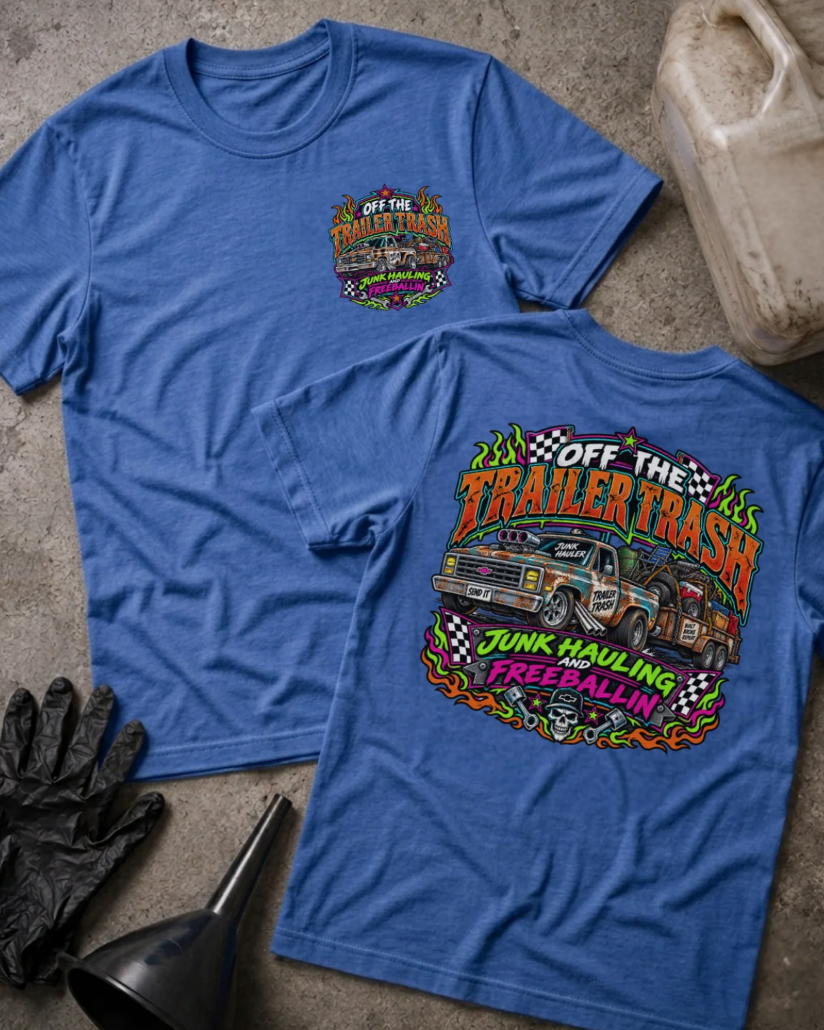 Front and back of Off the Trailer Trash heather true royal T-shirt with chest logo, rusty pickup towing a junk-filled trailer, and “Junk hauling and freeballin’” slogan.