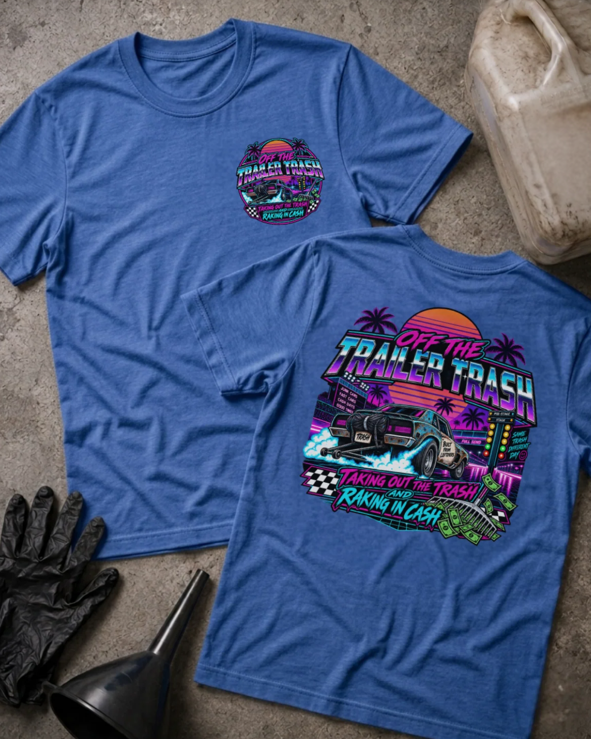 Front and back of Off the Trailer Trash heather true royal T-shirt with chest logo, drag car beneath a neon sunset and palm trees, and “Taking out the trash and raking in cash” slogan.