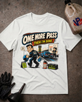 A white graphic t-shirt laid flat on a textured gray surface, featuring a cartoon illustration of a police officer taking a test with the text 'ONE MORE PASS THEN I'M DONE'. A black oil can, black gloves, and a funnel are arranged around the shirt as props.