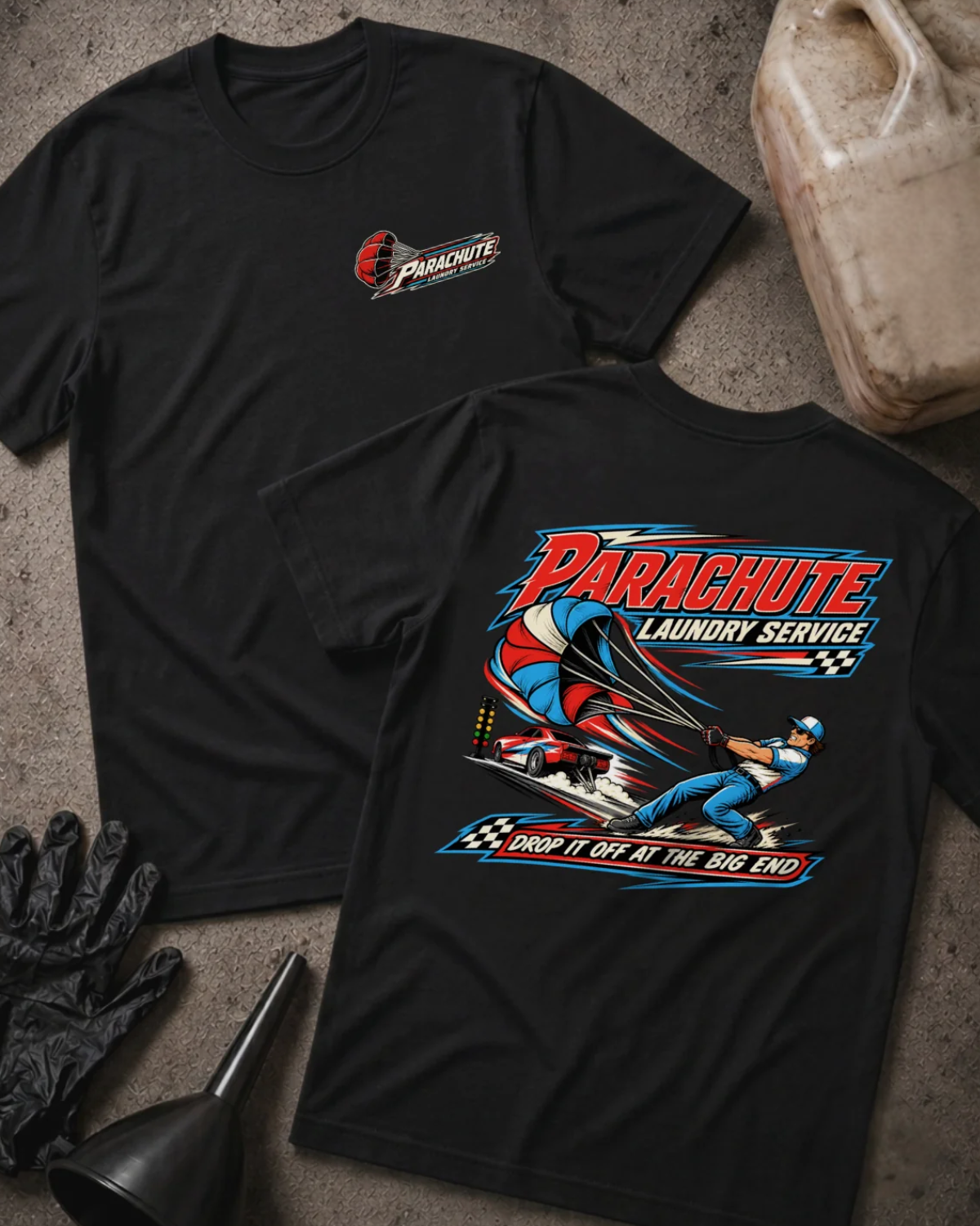 Front and back of Parachute Laundry Service black drag racing T-shirt with chest logo, crew member pulling a red, white and blue parachute beside a race car, and “Drop it off at the big end” slogan.