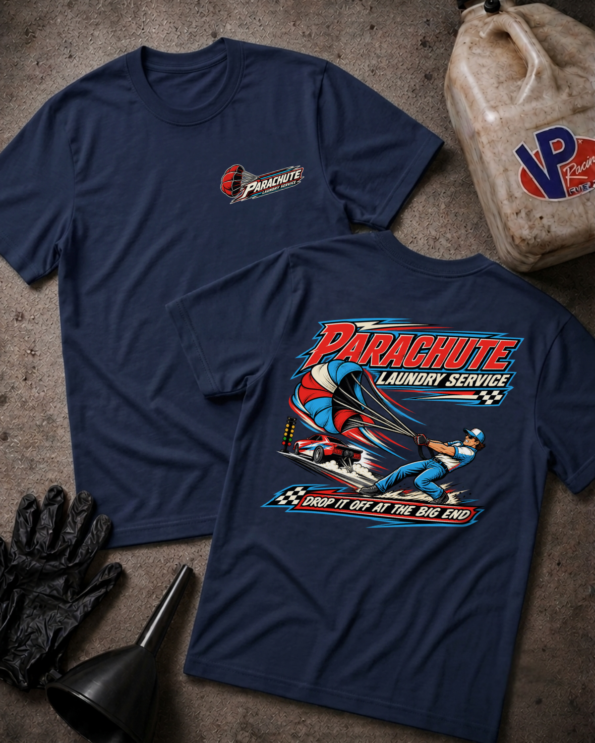 Two navy blue t-shirts displayed flat on a textured gray surface, showing the front and back graphics for 'Parachute Laundry Service'. A dirty plastic jug, black gloves, and a funnel are styled around the shirts.