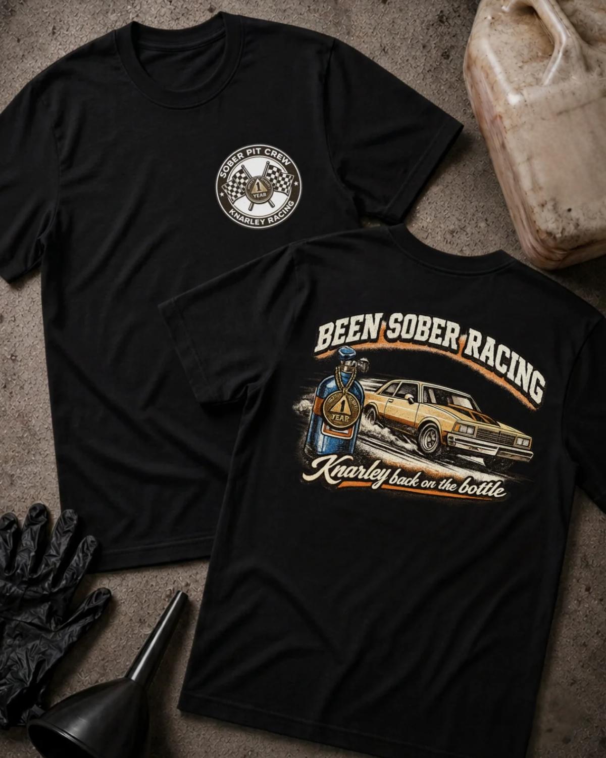 Front and back of black Been Sober Racing T-shirt with a Sober Pit Crew chest emblem and gold drag car beside a blue nitrous bottle, reading “Knarley Back on the Bottle.”