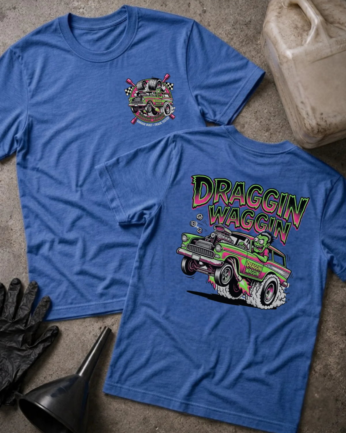 Front and back of heather true royal blue Draggin Waggin T-shirt with a small chest emblem and green and pink hot rod wagon with a cartoon monster driver on the back.