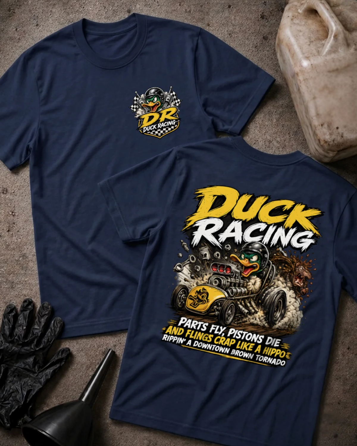 Front and back of navy Duck Racing T-shirt with a checkered-flag chest emblem and helmeted cartoon duck driving a yellow hot rod amid smoke and flying engine parts.