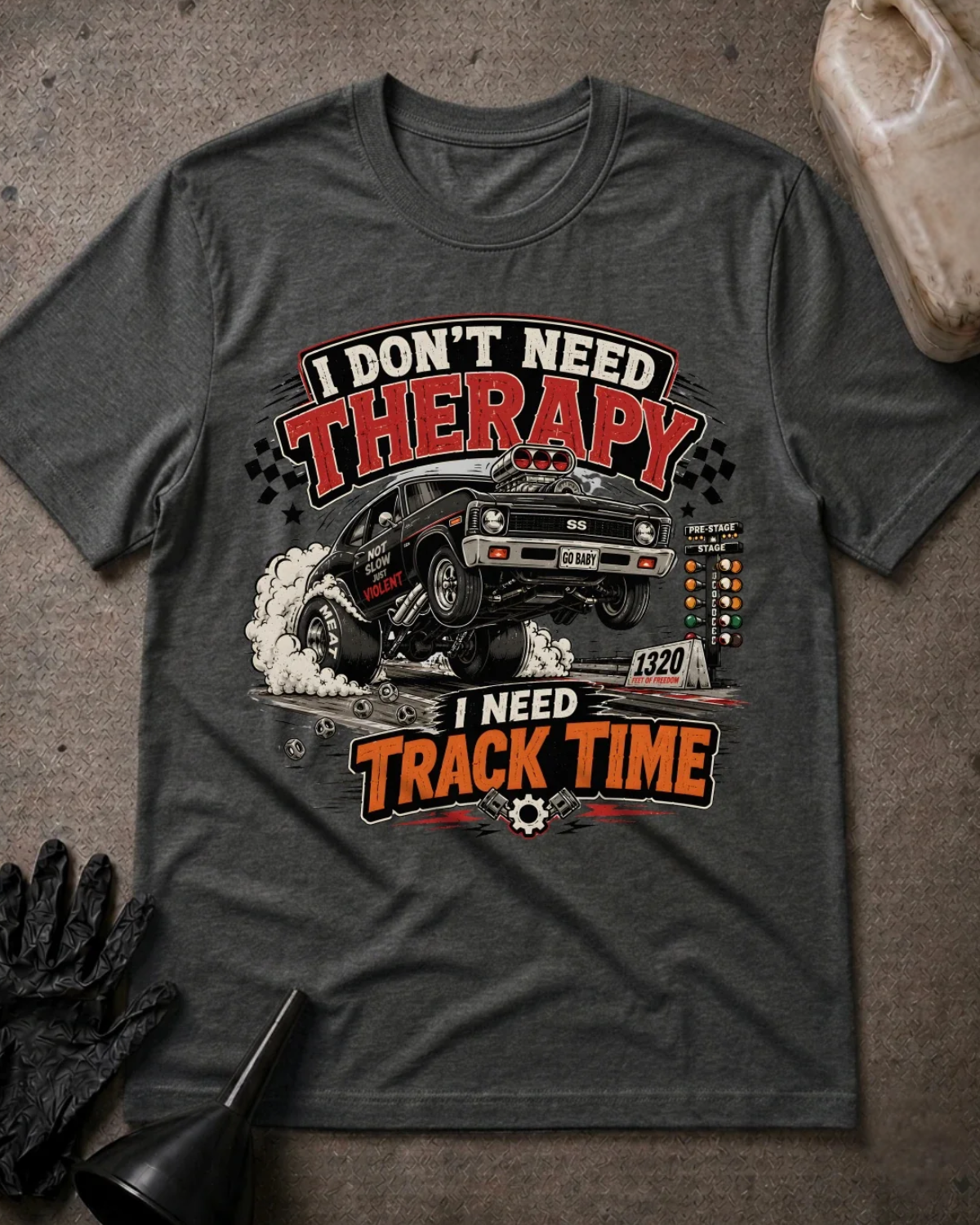 Front of dark grey heather T-shirt with a black drag car lifting its front wheels beside a starting tree, reading “I Don’t Need Therapy, I Need Track Time.”