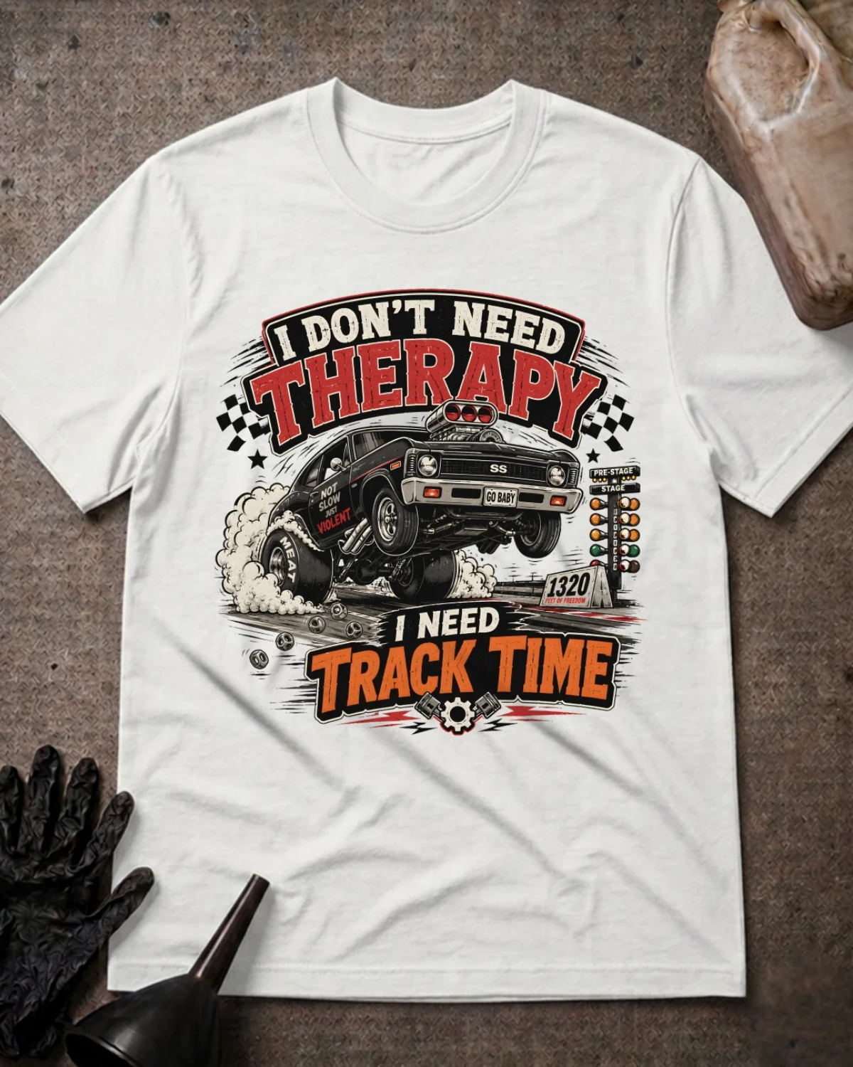 Front of white T-shirt with a black drag car lifting its front wheels beside a starting tree, reading “I Don’t Need Therapy, I Need Track Time.”