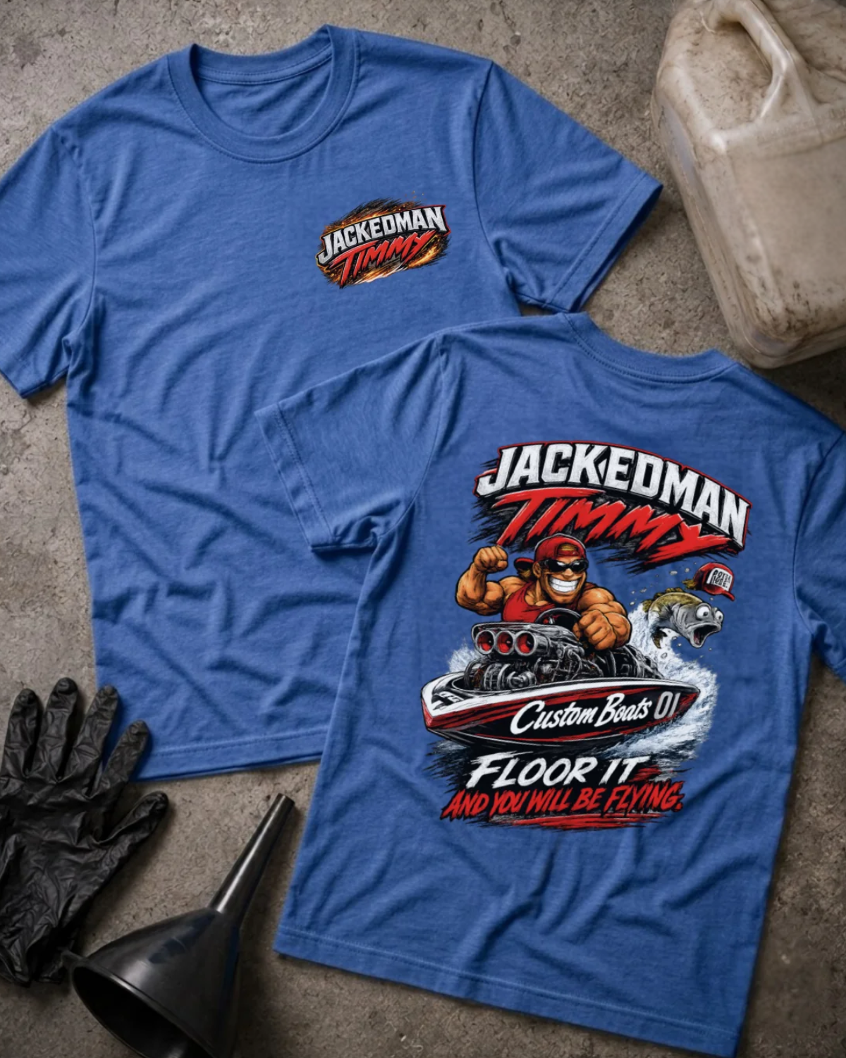 Front and back of heather true royal blue Jackedman Timmy T-shirt with a chest logo and cartoon muscular driver in a drag racing boat beside a leaping fish on the back.