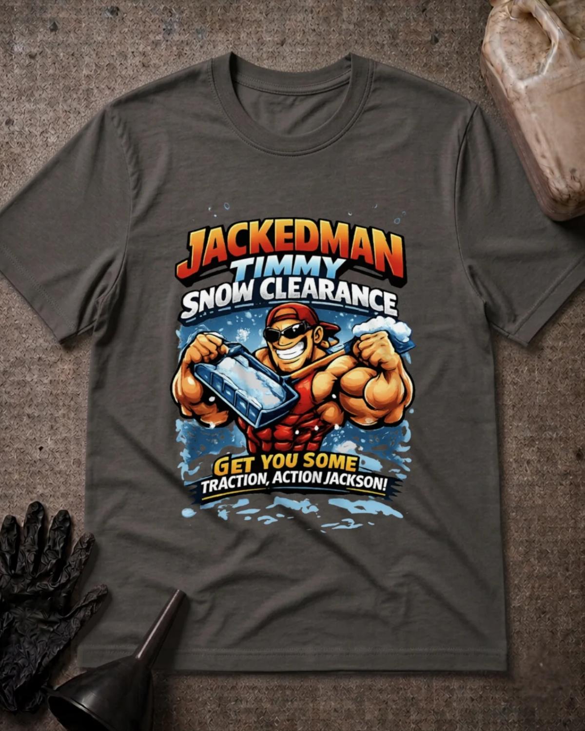 Asphalt gray Jackedman Timmy Snow Clearance T-shirt featuring a muscular cartoon man in sunglasses and a backward red cap holding a snow shovel, with the slogan “Get you some traction, Action Jackson!”