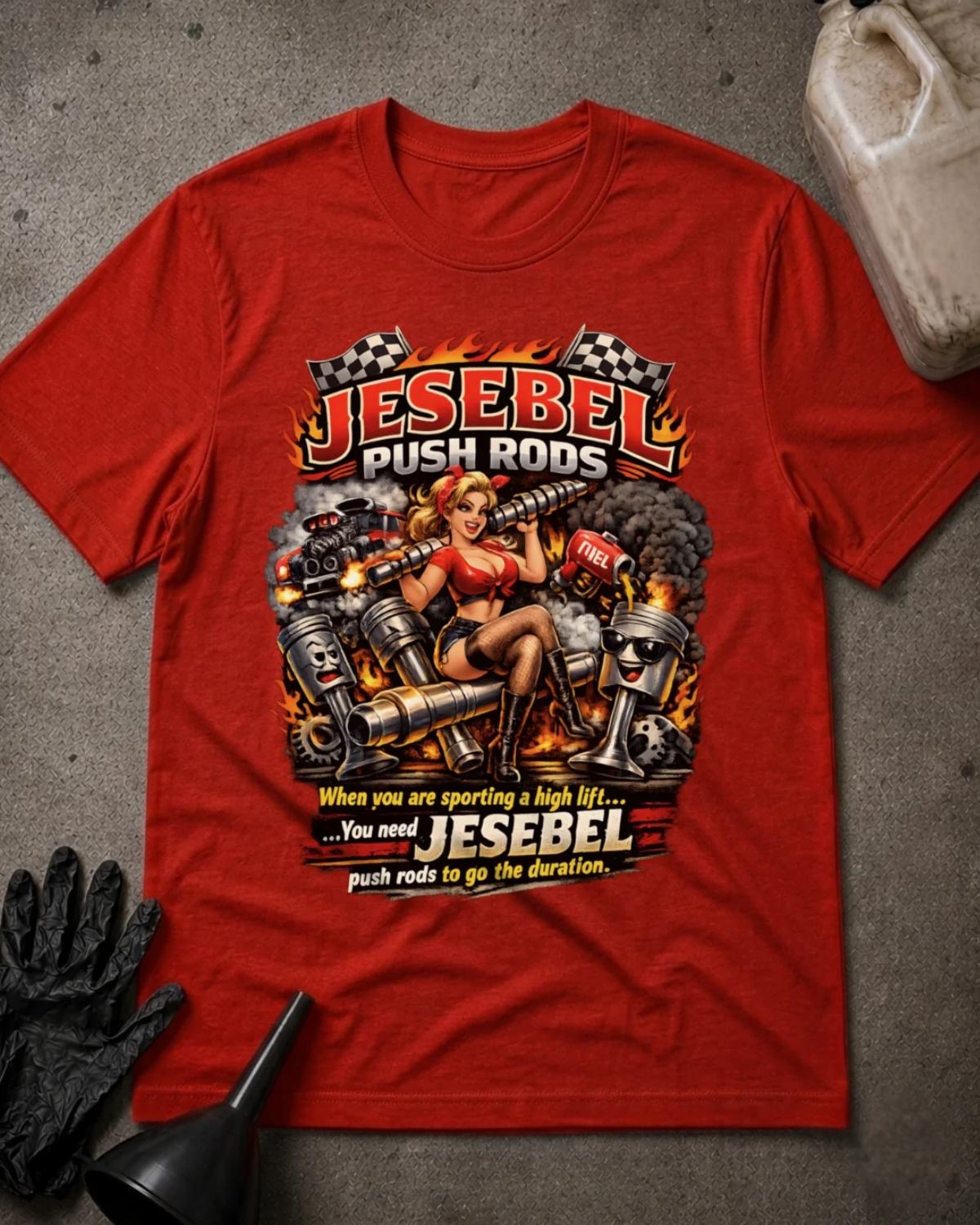 Front of red Jesebel Push Rods T-shirt with a pinup woman holding an engine camshaft amid cartoon pistons, flames, smoke and checkered flags.