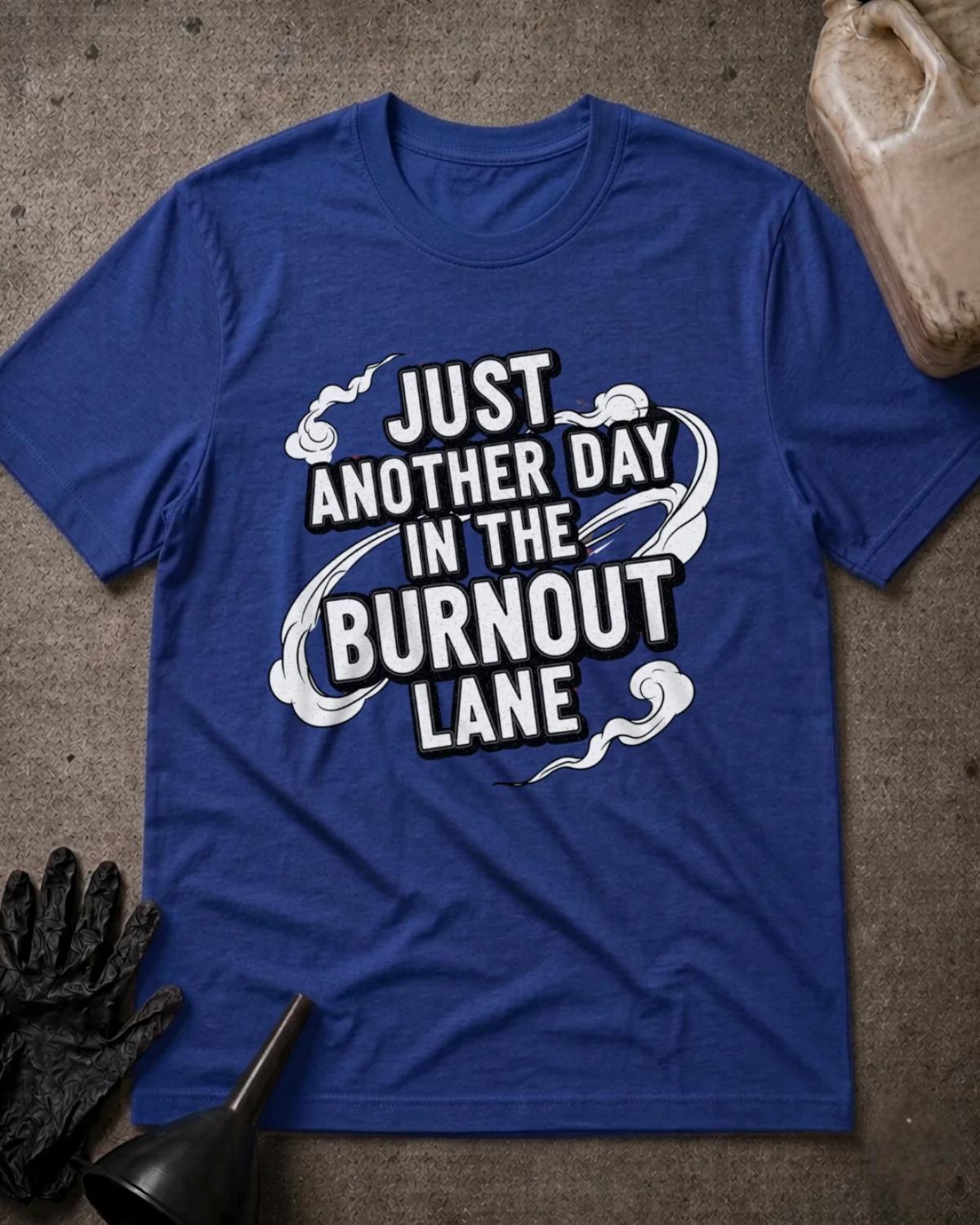 True Royal blue drag racing T-shirt featuring bold white lettering with black outlines reading “Just another day in the burnout lane,” surrounded by swirling tire smoke.