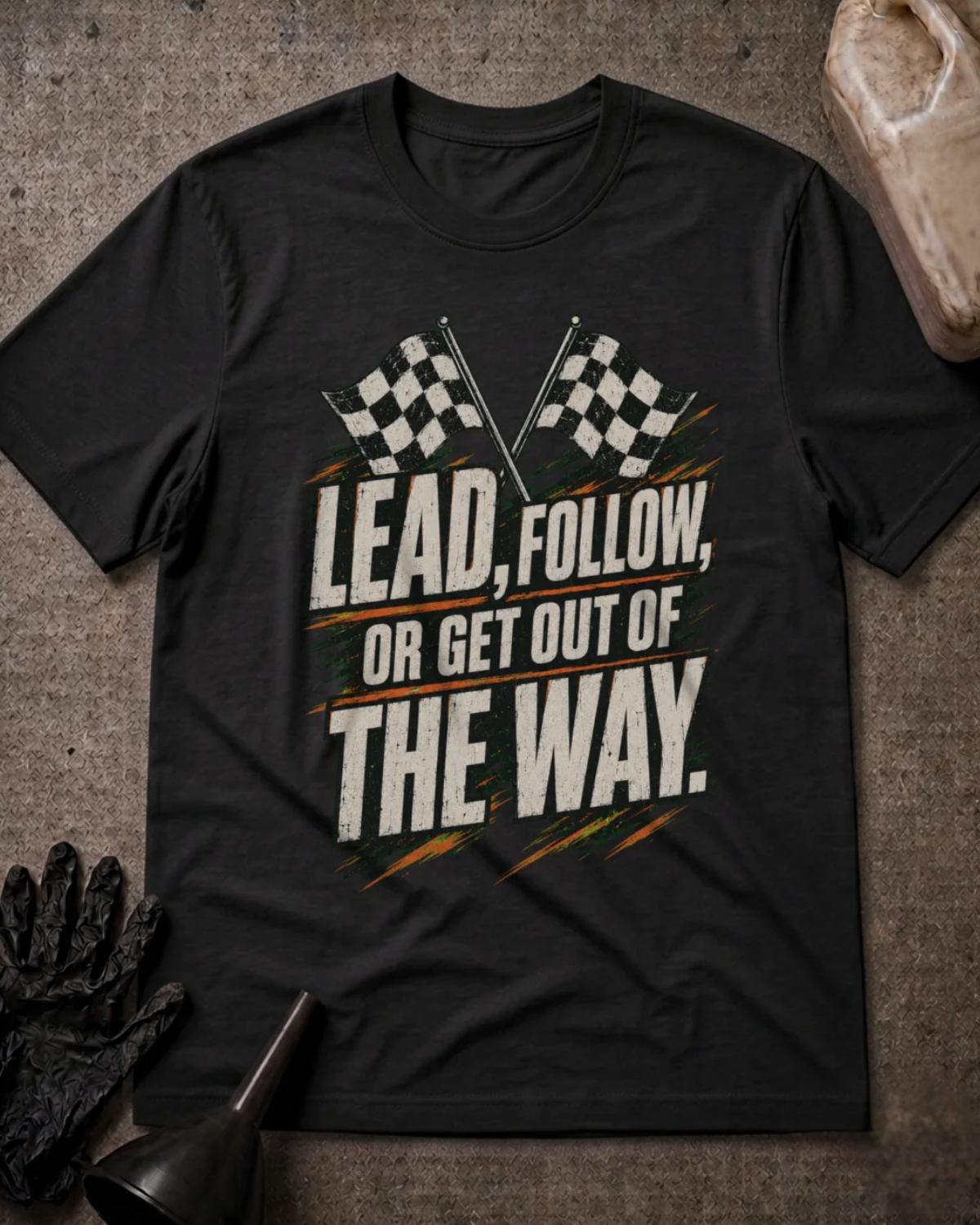 Front of black T-shirt with crossed checkered racing flags and distressed lettering reading “Lead, Follow, or Get Out of the Way.”