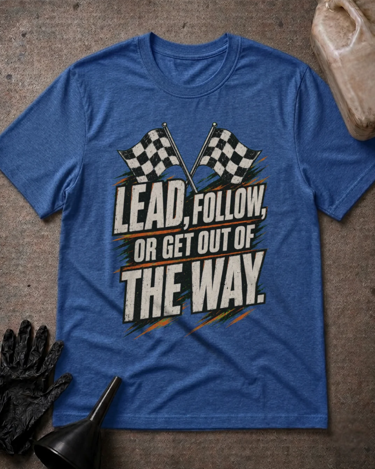Front of heather true royal blue T-shirt with crossed checkered racing flags and distressed lettering reading “Lead, Follow, or Get Out of the Way.”