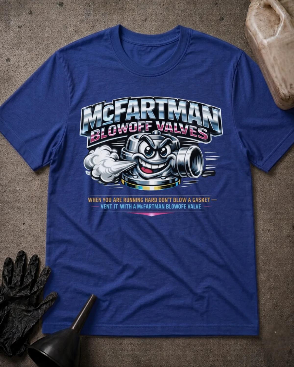 Front of true royal blue T-shirt with a grinning cartoon automotive blowoff valve venting air beneath silver and pink “McFartman Blowoff Valves” lettering.
