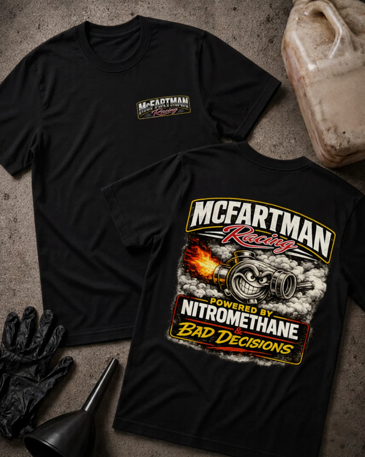 Front and back of black McFartman Racing T-shirt with a chest logo and grinning turbocharger amid flames and smoke, reading “Powered by Nitromethane & Bad Decisions.”