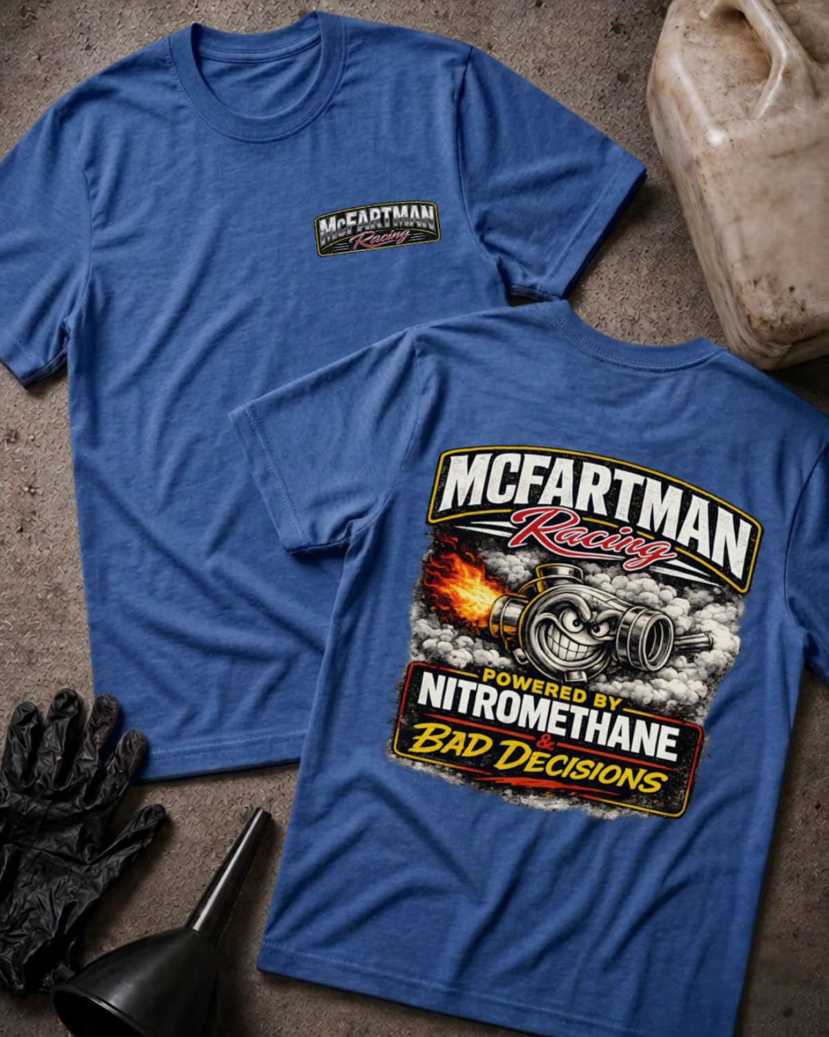 Front and back of heather true royal blue McFartman Racing T-shirt with a chest logo and grinning turbocharger amid flames and smoke, reading “Powered by Nitromethane & Bad Decisions.”
