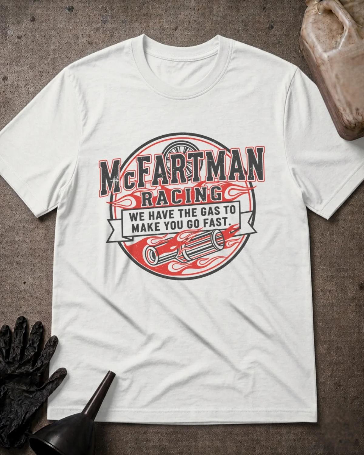 White McFartman Racing T-shirt featuring a circular emblem with red flames, exhaust pipes, a wheel, and the slogan “We have the gas to make you go fast.”⠋