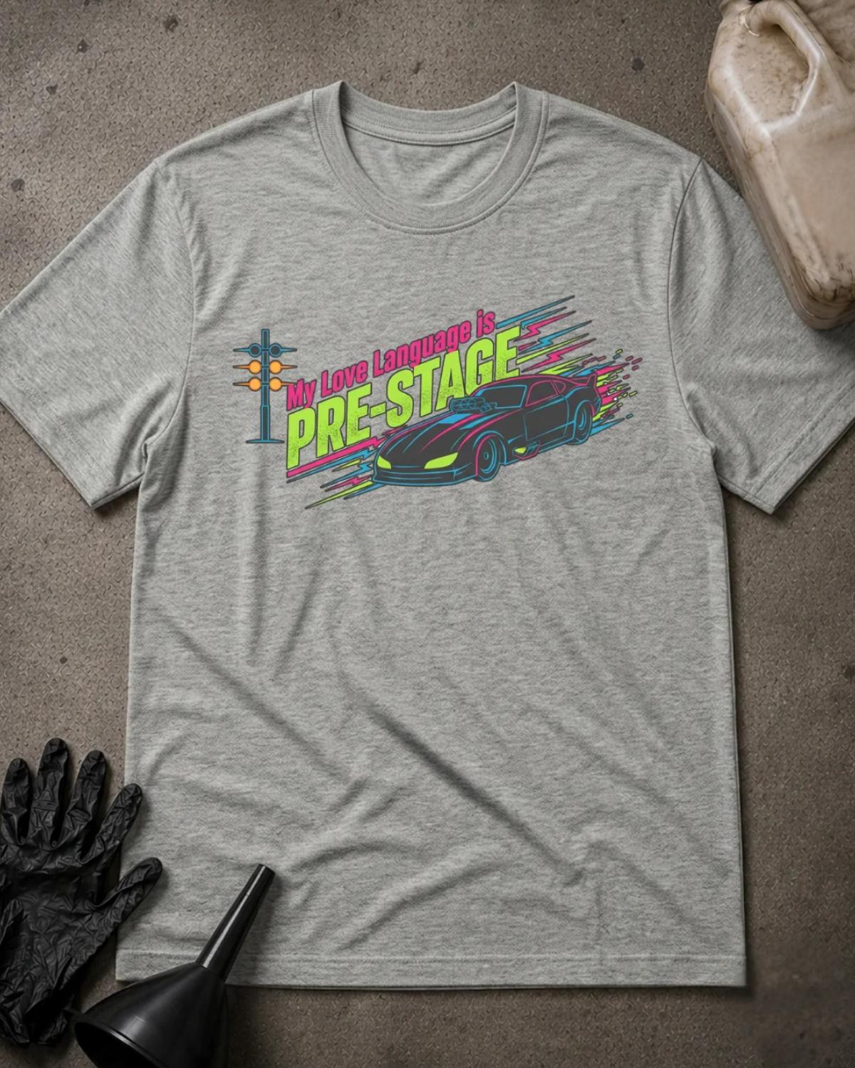 Athletic Heather gray drag racing T-shirt featuring neon pink and lime “My love language is pre-stage” lettering, a sports car, a starting light, and colorful speed lines.