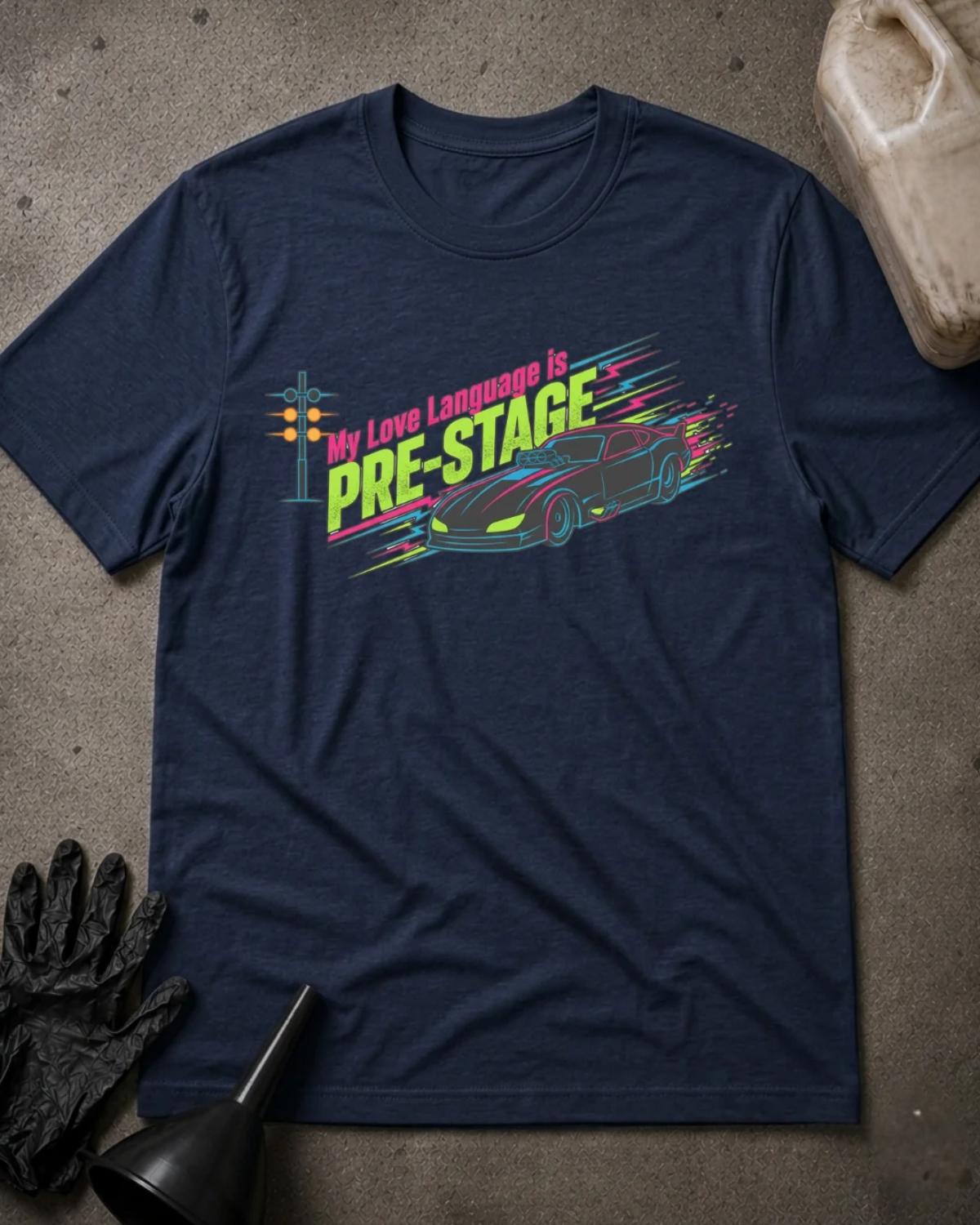 Navy drag racing T-shirt featuring neon pink and lime “My love language is pre-stage” lettering, a sports car, a starting light, and colorful speed lines.