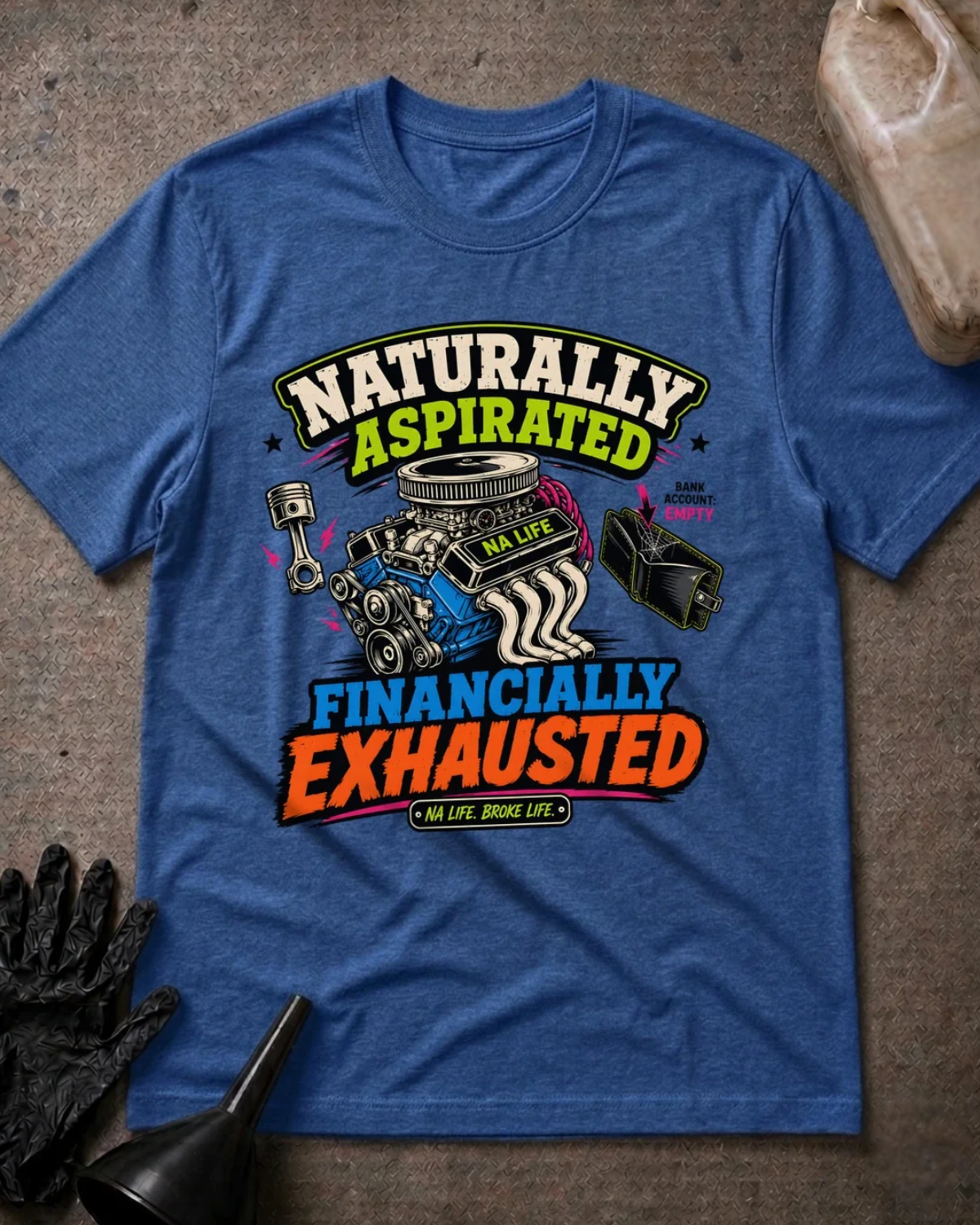 Front of heather true royal blue T-shirt with an engine, piston and empty wallet graphic reading “Naturally Aspirated, Financially Exhausted.”